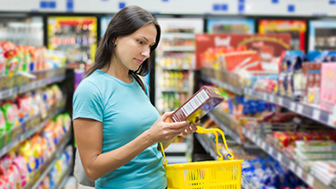 Woman checking food labels at a supermarket.